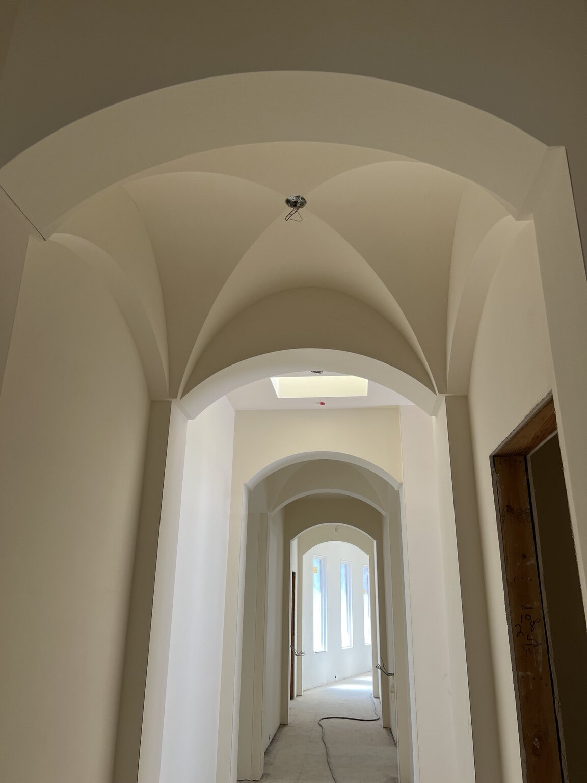 Restored vaulted hallway with repeated arches in the Los Gatos residence