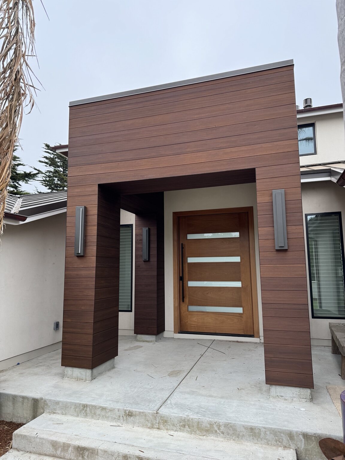 Custom wood-clad entry and front door at the Opal Cliffs home