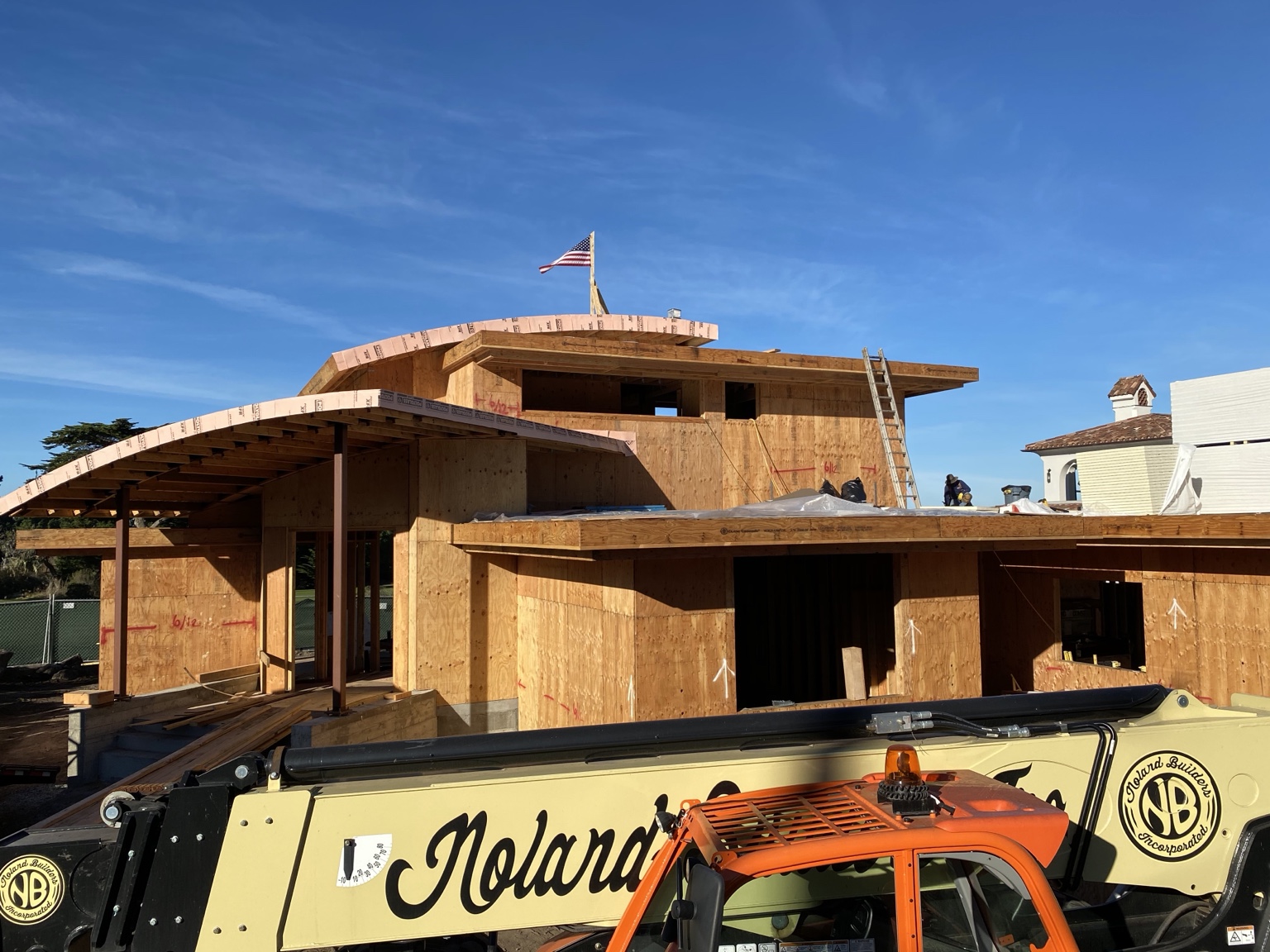 Pebble Beach custom home under construction with Noland Builders equipment on site