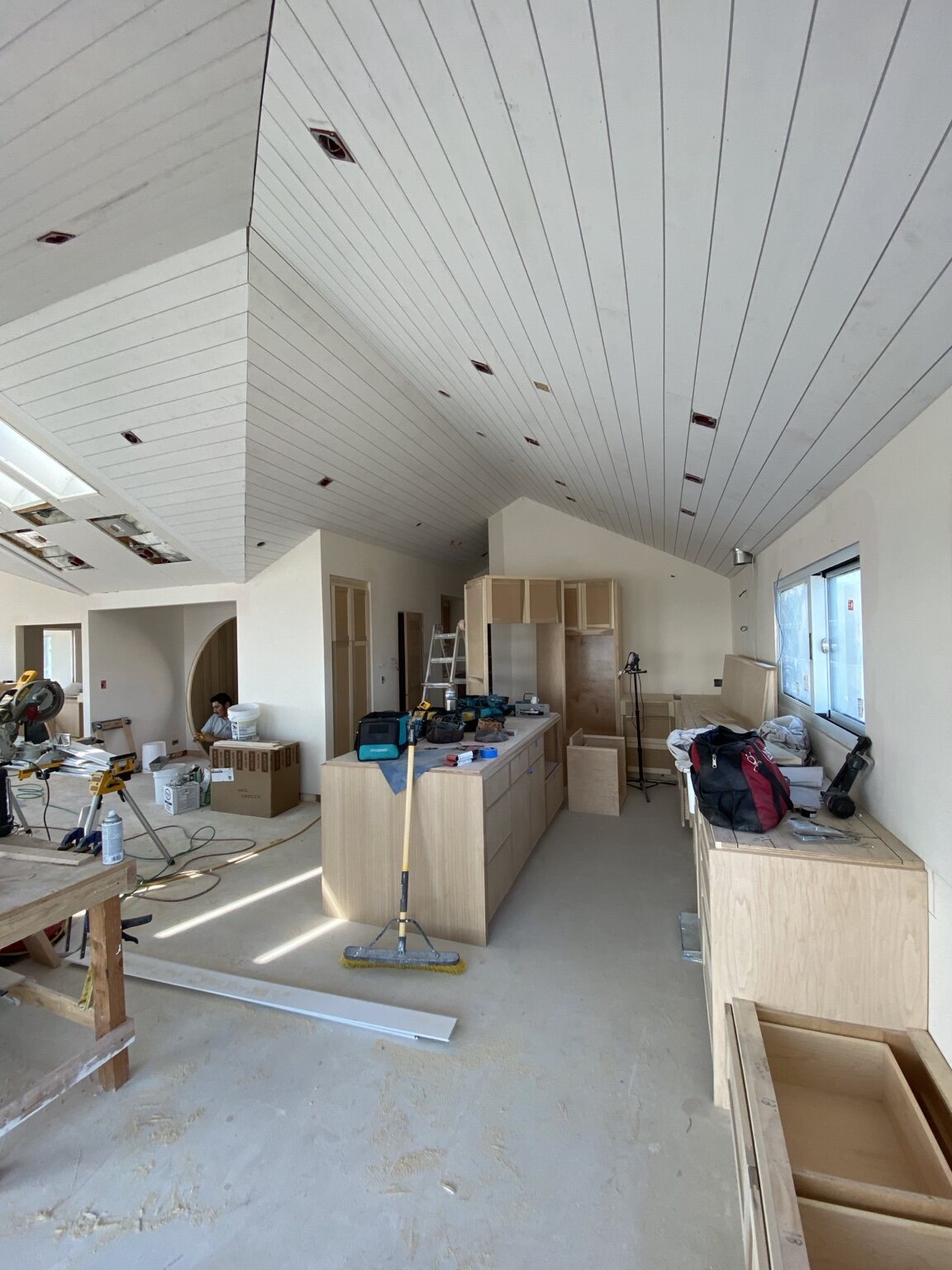 Vaulted interior with custom cabinetry and tongue-and-groove ceiling installation